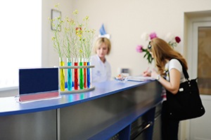 Woman paying for care at dental office front desk