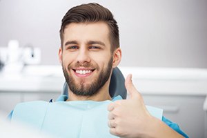 Relaxed man in treatment chair giving thumbs up for dental sedation in Worcester
