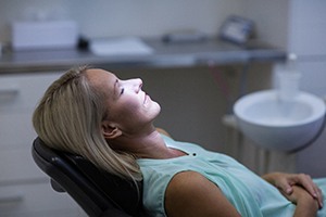 Woman reclining in a dental examination chair after taking oral conscious sedation