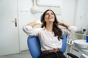 Closeup of dentist typing on calculator next to a model tooth