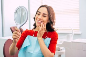 a woman admiring her smile in the mirror