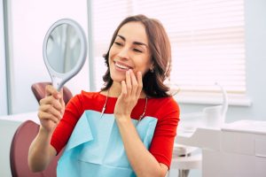 a woman admiring her smile in the mirror