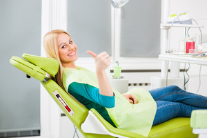 Blonde female patient giving a thumbs up