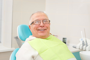 Periodontal patient sitting in chair and smiling