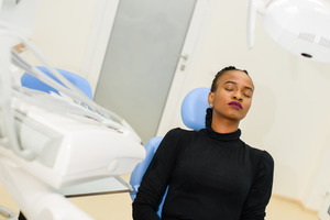 Relaxed woman leaning back in chair at periodontist’s office