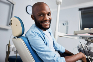 Smiling man in treatment chair at periodontist’s office