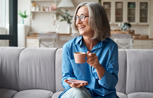 Senior woman sitting on couch and smiling